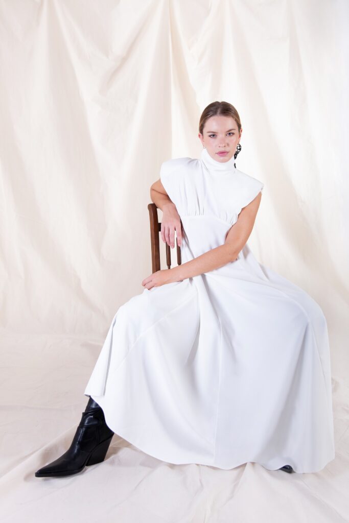 Istuv naine pikas valges kleidis. Austraalia disain